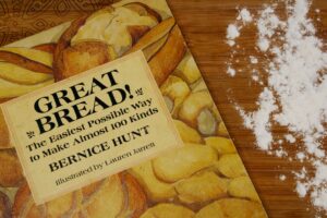 Hands kneading perfectly risen dough at high altitude, demonstrating successful yeast adjustment for baking.